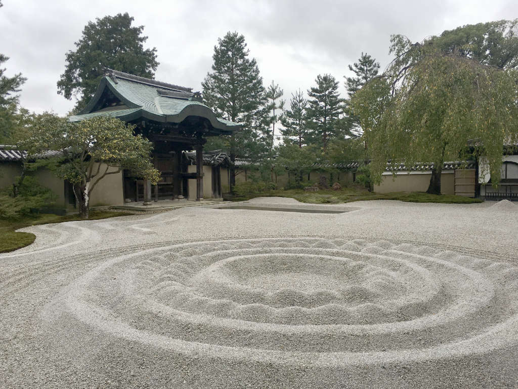 Jardin zen avec grande étendue de sable ratissé